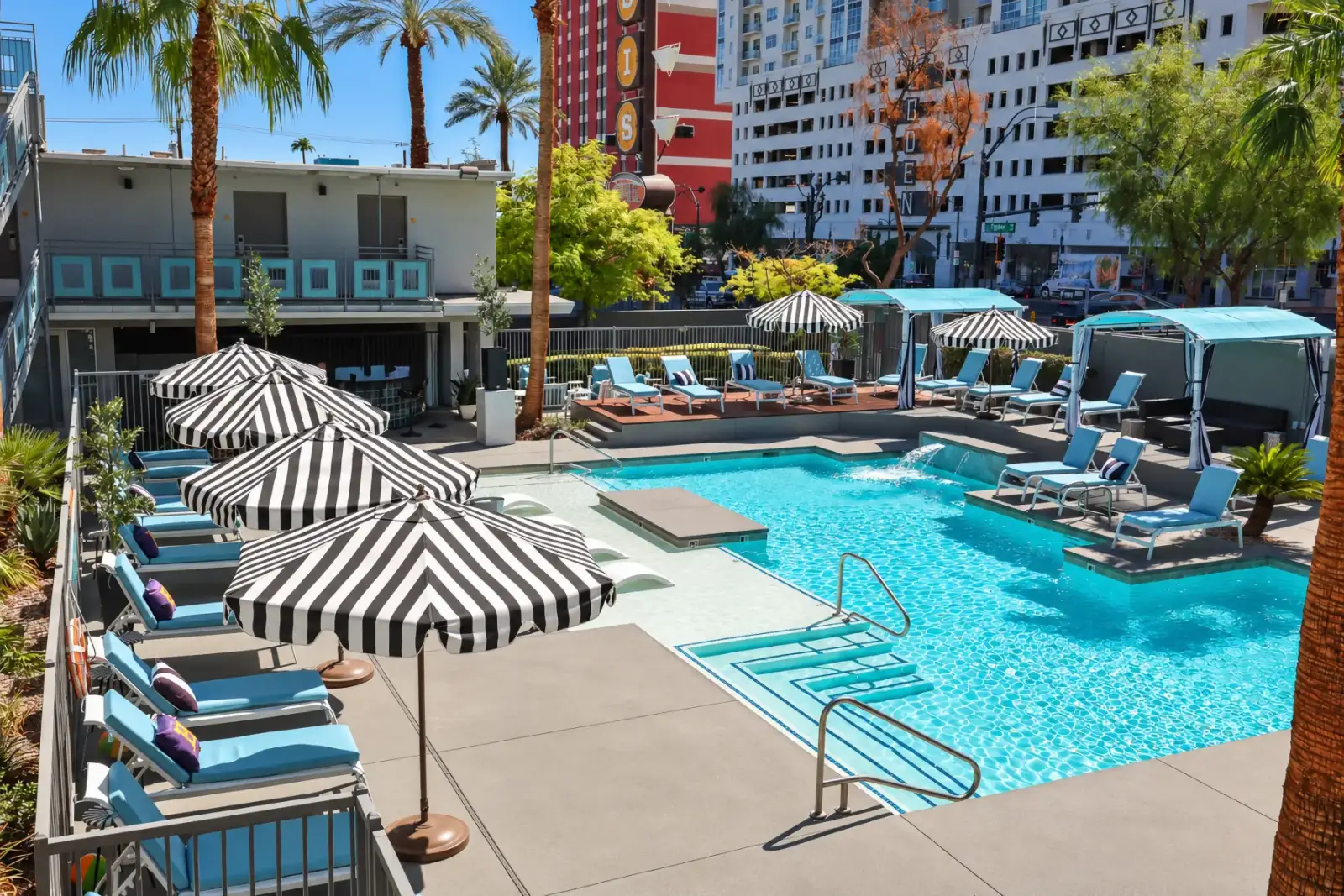 The Oasis pool deck with striped umbrellas and cabanas
