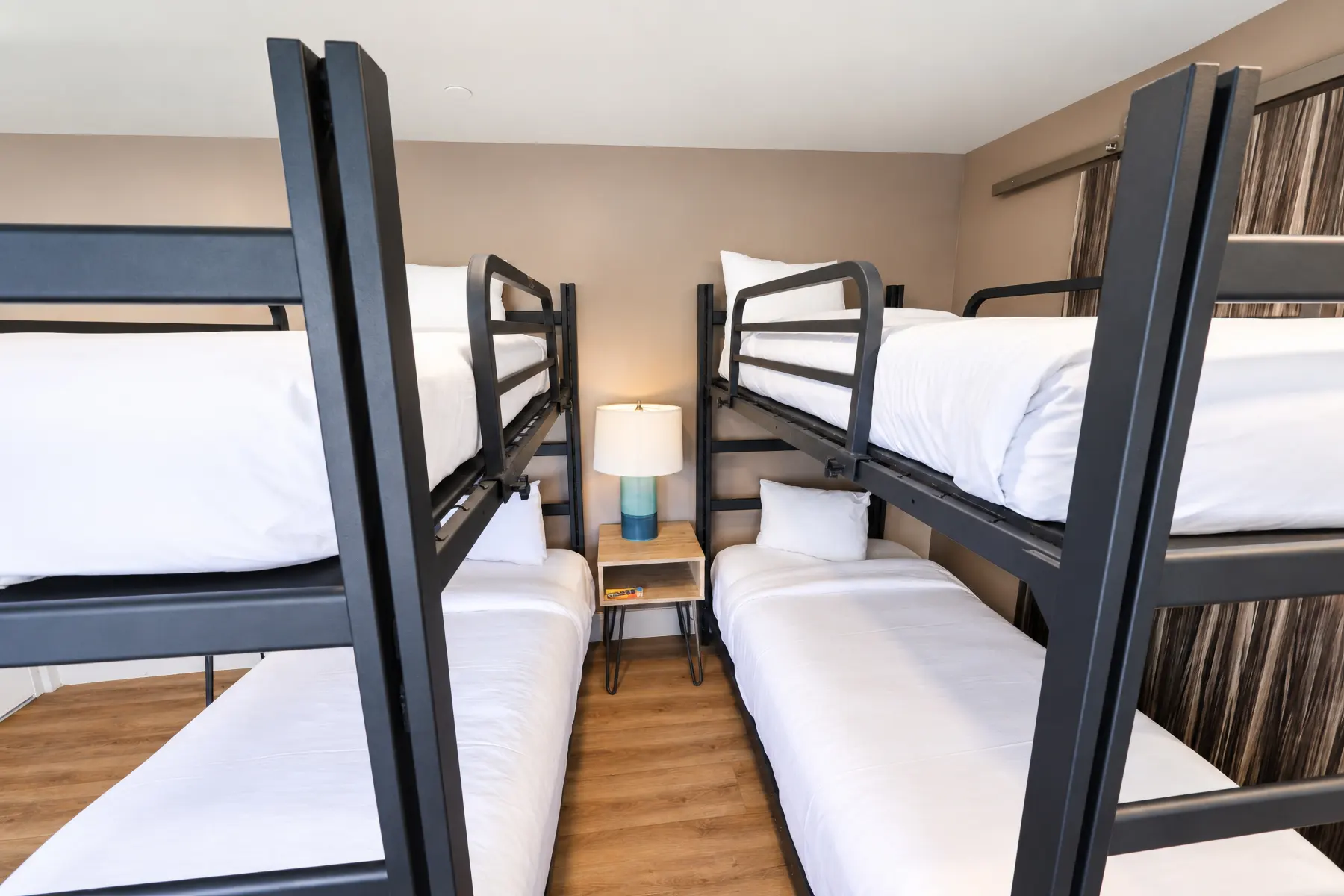 Two sets of bunk beds with a nightstand between them